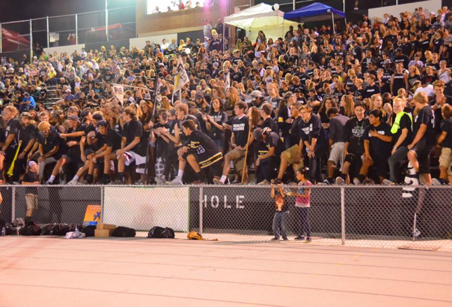 Seniors stand in the front of the Black Hole during a football game.
