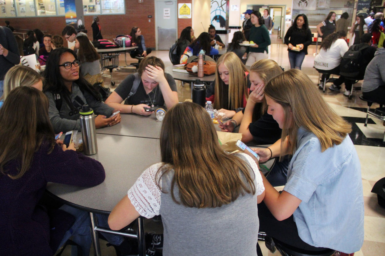 Students distracted by their phones at the lunch table