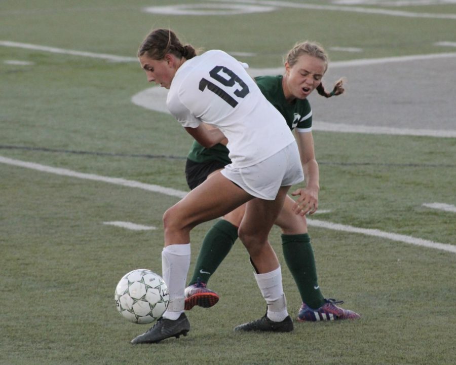 Highlands #19 Annie Murdock keeping control of the ball from an Olympus player.