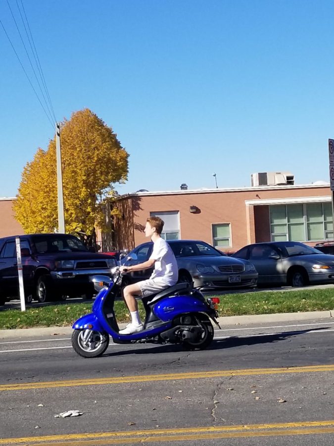Josh Richards rides his moped through Highlands parking lot.
