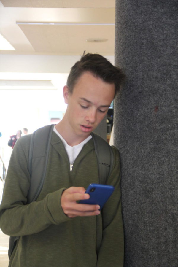 Wil Beasley looks at his phone, something teens are doing more frequently than ever.
