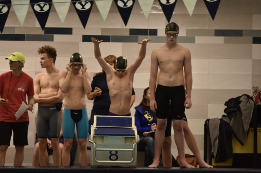 Members of Highlands mens 200 yard medley relay stand behind the block in preparation for their race.  