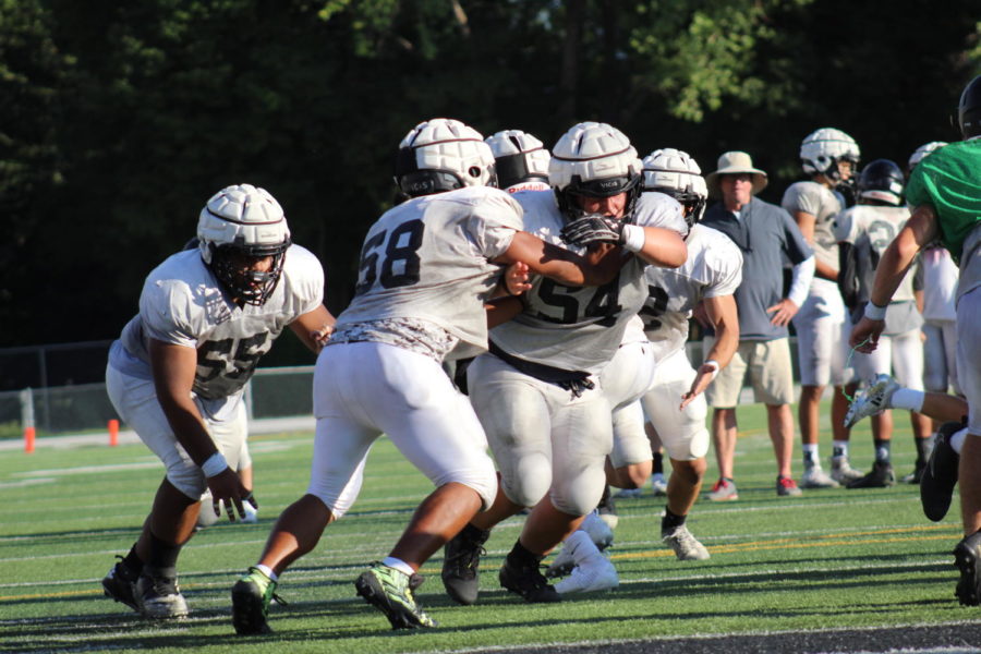 Jaxsen Miner (54) blocks from his center position during the Black and White scrimmage.