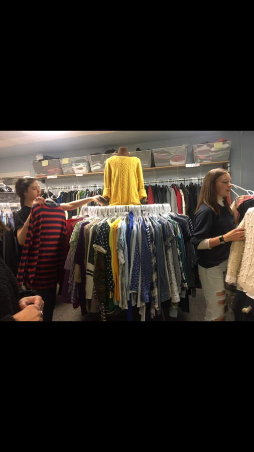 Students work in the Highland Market to organize clothes for those who need them.