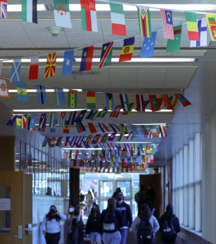 Highland Students walk in E-hall under new banners showing flags from around the world