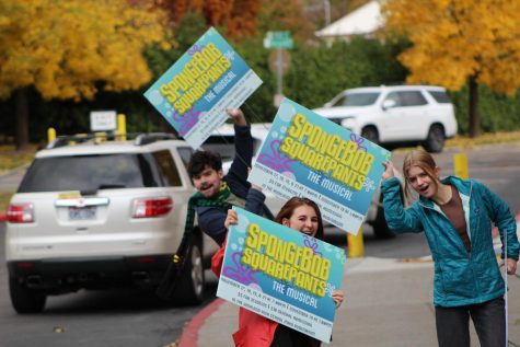 (From left to right) Tate Nichols (12), Sarah Kurth (11), and Savannah Moon (10) put up SpongeBob signs outside of Highland.