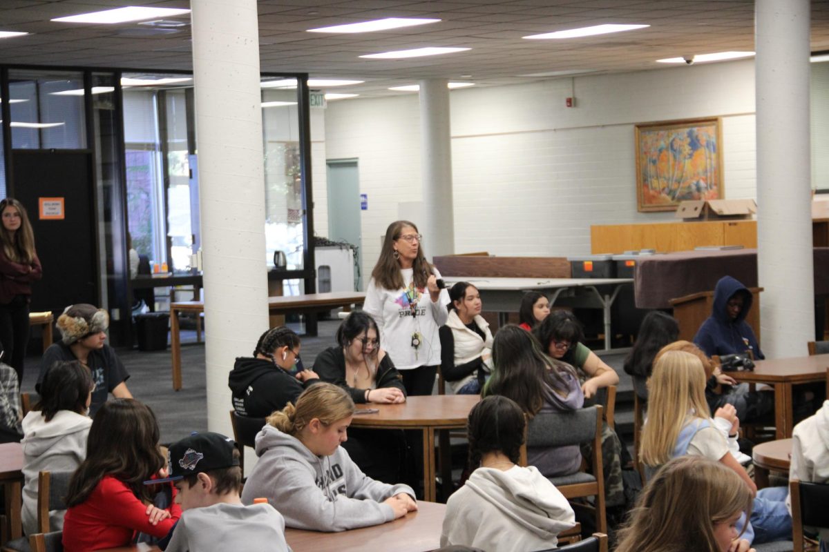 A counselor presents to a group of sophomores in the library. 