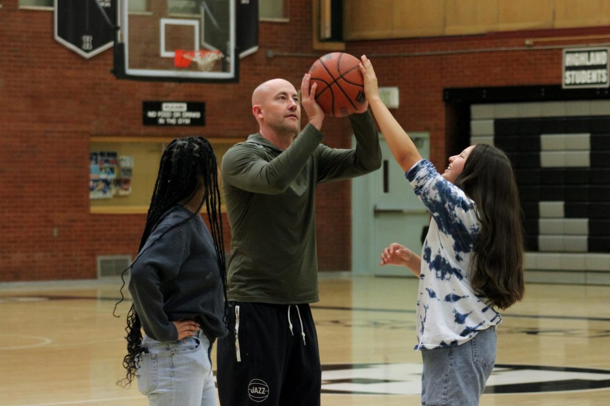 Highland SRO officer Tyler Venema playing basketball with students. 