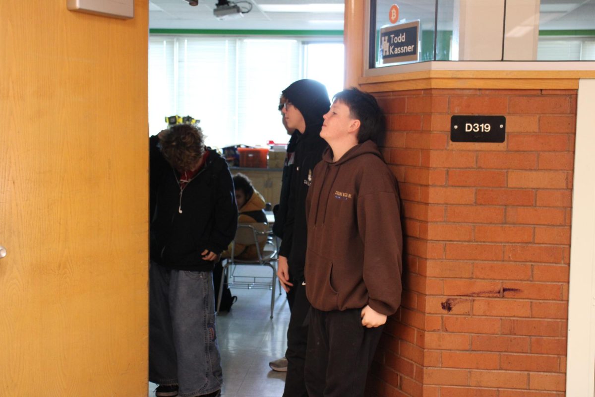 Students line up by the door, waiting for class to get out.