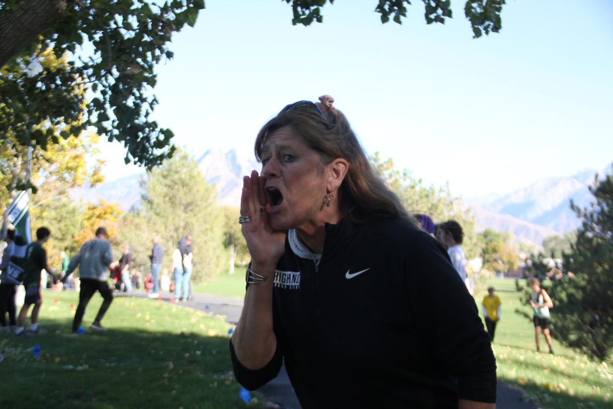 Coach Humbert coaching kids at a cross country meet.