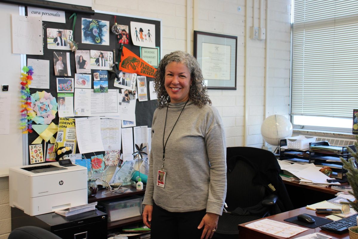 Deirdre Straight poses in front of her desk in the freshman success room.