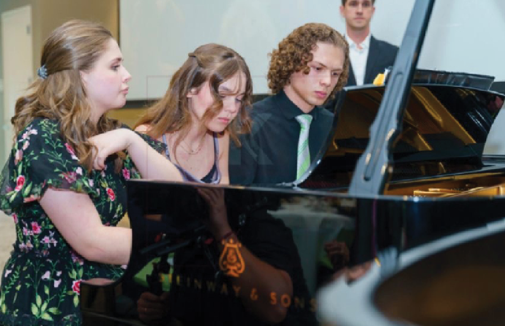 Lottie Hicks (center) performing at a piano competition. 