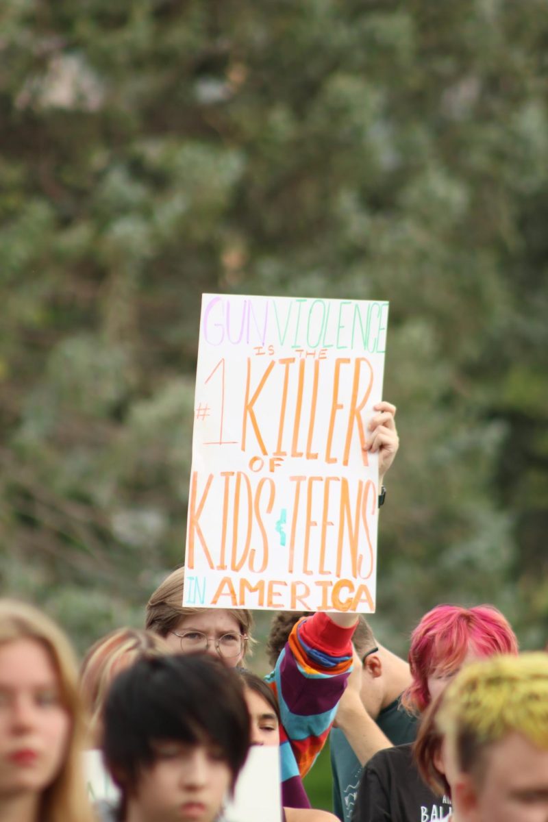 Lydia Riesen holds a sign during the walkout for Safer Schools on Friday, September 5th.