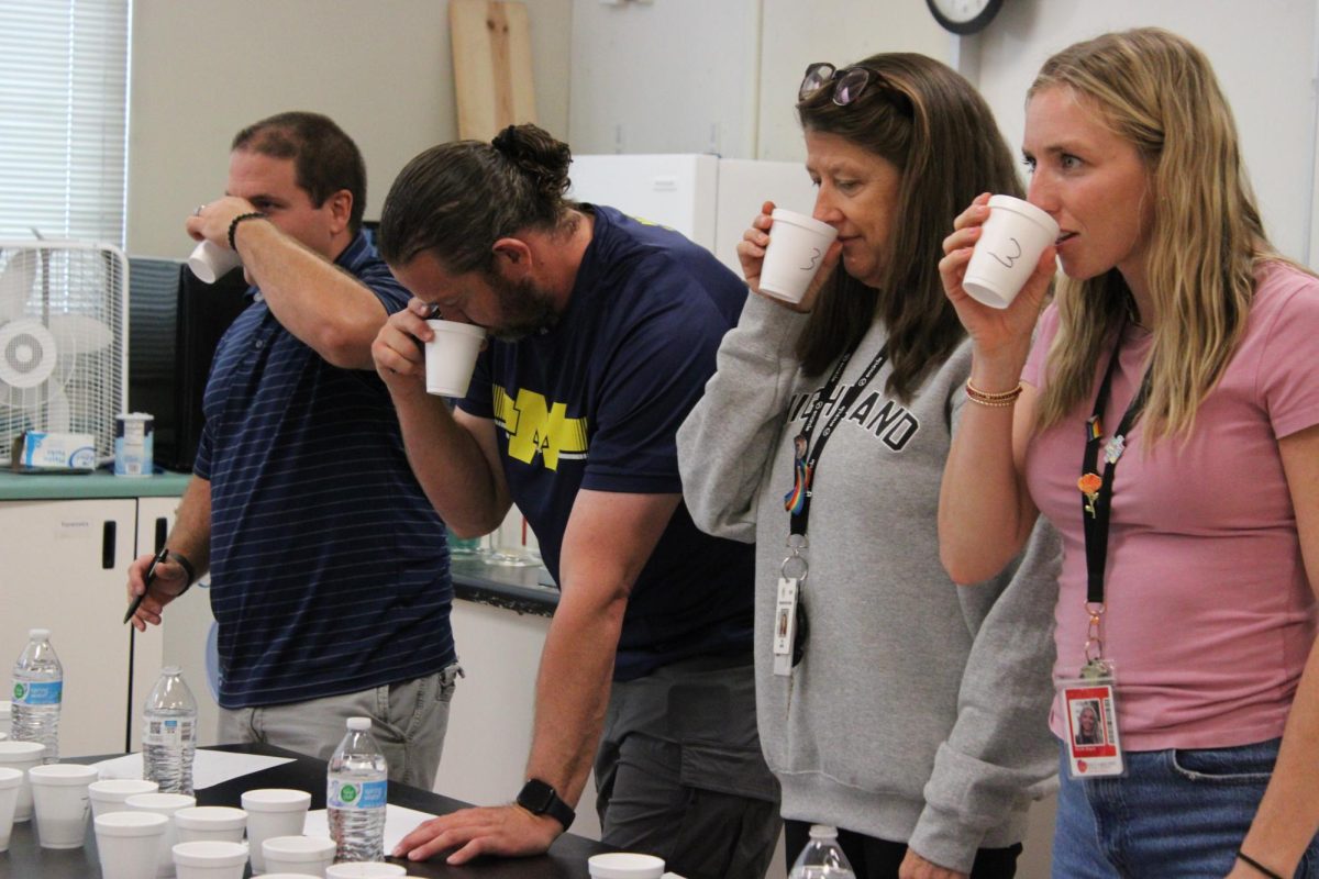 Teachers taste testing the root beer during a taste competition.