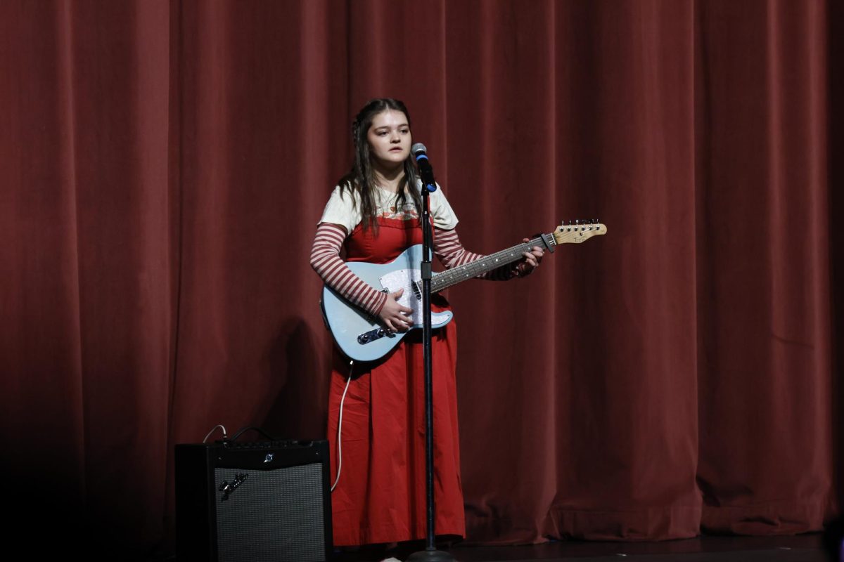 Nellie Campbell singing on stage during the Highland talent show.