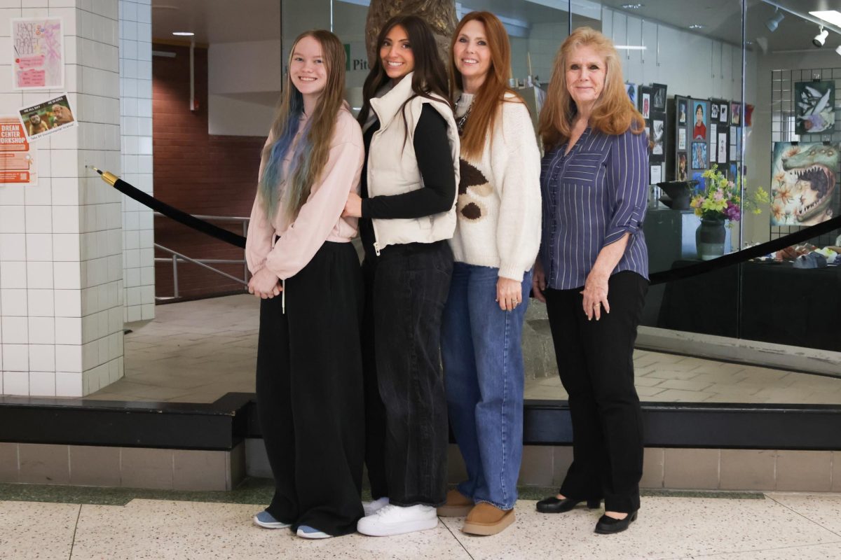 Peyton Allred (left), Haley Vaifoou, Kim Van Wagoner, and Karrie Allred (right) pose in front of the ram statue. 